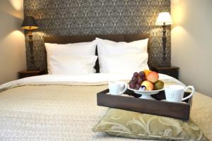 a tray with a bowl of fruit on a bed at Willa Sepia SPA in Wisła