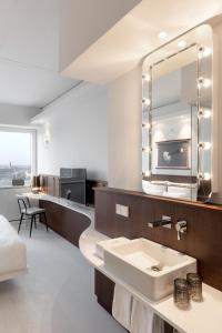 a bathroom with a sink and a large mirror at Ruby Luna Hotel Dusseldorf in Düsseldorf