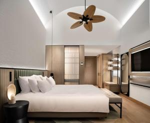 a bedroom with a bed and a ceiling fan at Radisson Collection Hotel, Bodrum in Akyarlar