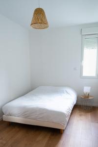 a bedroom with a white bed and a window at Appartement cosy dans une longère de caractère in Saumur