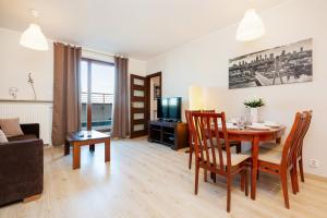 a living room with a table and chairs and a couch at Apartamenty Bliska Praga by Renters in Warsaw