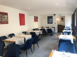 une salle à manger avec des tables et des chaises bleues dans l'établissement L'Otentik Restaurant Chambres d'Hôtes, à Rosporden