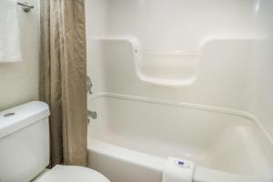 a bathroom with a toilet and a tub and a toilet paper roll at Motel 6-Irving, TX - Dallas in Irving