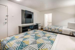 a hotel room with two beds and a television at Motel 6-Irving, TX - Dallas in Irving