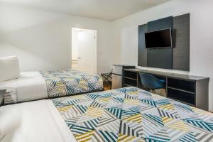 a hotel room with two beds and a desk at Motel 6-Irving, TX - Dallas in Irving