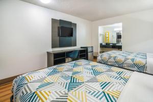 a hotel room with two beds and a flat screen tv at Motel 6-Irving, TX - Dallas in Irving