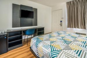 a hotel room with a bed and a flat screen tv at Motel 6-Irving, TX - Dallas in Irving