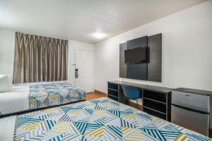 a hotel room with two beds and a flat screen tv at Motel 6-Irving, TX - Dallas in Irving