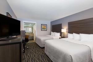 a hotel room with two beds and a flat screen tv at Days Inn by Wyndham Ukiah in Ukiah