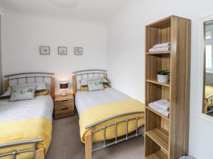a bedroom with two beds and a mirror at Bryn Hafod in Conwy