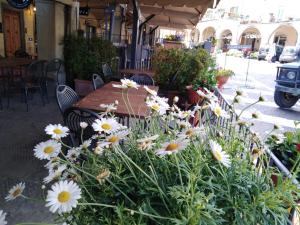 un tavolo e fiori di fronte a un tavolo e sedie di Albergo Giovanni Da Verrazzano a Greve in Chianti