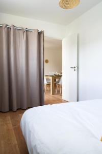 Appartement cosy dans une longère de caractère في سوموور: غرفة نوم بسرير وغرفة مع طاولة
