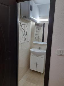 a bathroom with a sink and a mirror at Garsoniera Saturn in Saturn
