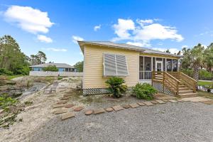 a small yellow house with a porch and stairs at The Rookery Unit 3501 in Gulf Shores