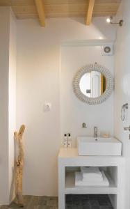 a white bathroom with a sink and a mirror at Sanidiamonds in Sani Beach