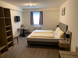 1 dormitorio con cama y escritorio. en Hotel Montag en Sankt Goar