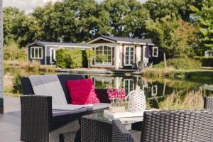a backyard patio with a couch and a house on the water at Twente 4 persons in Rijssen