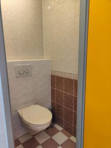 a bathroom with a toilet and a tiled floor at Hotel Domburg4you in Domburg