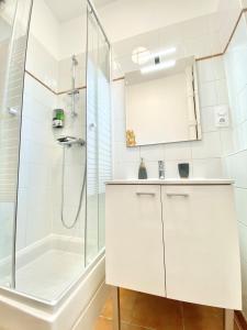 une salle de bain blanche avec une douche et un lavabo dans l'établissement Balcon du Faron- Proche Gare & Centre ville - Clim, à Toulon