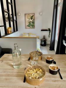 a table with bowls of food and a bottle of water at Balcon du Faron- Proche Gare & Centre ville - Clim in Toulon +4 photos
