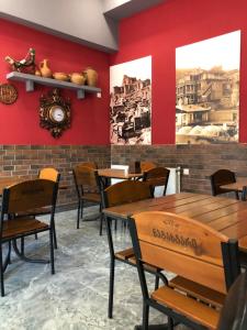 un restaurante con paredes rojas, mesas de madera y sillas en Hotel Nabadi en Tiflis