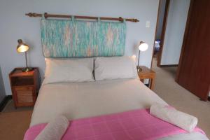 a bedroom with a large bed with a pink blanket at On the beach living! 12 Calamari in Margate