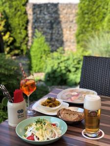 a table with plates of food and a glass of beer at Hotel & Gasthof Wagner in Aichach