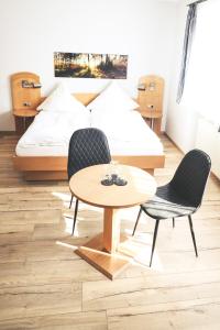 a bedroom with a bed and a table and chairs at Hotel & Gasthof Wagner in Aichach