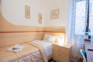 1 dormitorio con 1 cama, vestidor y ventana en Appartamento accanto ai Mercatini di Natale, en Trento