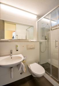 uma casa de banho com um lavatório, um WC e um chuveiro em Hotel Egerkingen, idealer Zwischenstopp em Egerkingen