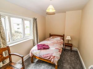 a bedroom with a bed and a window at Idan House in Llanfairpwllgwyngyll