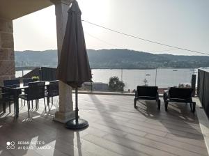 an umbrella on a balcony with a view of the water at Mirador Ría de Aldán Apartamentos in Aldán