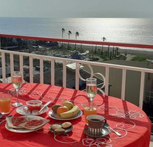 a table with food and drinks on a red table cloth at terraza al mar in Pineda de Mar