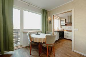 a dining room with a table and a large window at Holyday apartment in Haapsalu