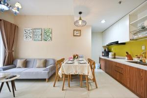 a kitchen and a living room with a table and a couch at High Class 2 Bedrooms Masteri Thao Dien Apartment, Fully Furnished With Full Amenities in Ho Chi Minh City