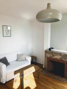 sala de estar con sofá blanco y chimenea en Le seize, en Châlons-en-Champagne