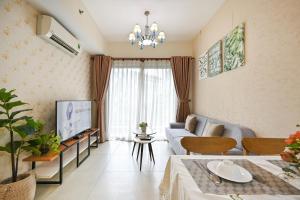 a living room with a couch and a tv at High Class 2 Bedrooms Masteri Thao Dien Apartment, Fully Furnished With Full Amenities in Ho Chi Minh City