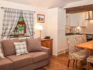 a living room with a couch and a kitchen at The Church Inn Cottage in Buxton