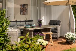 a patio with a table and chairs and an umbrella at Techts Apartmenthaus in Timmendorfer Strand +72 photos
