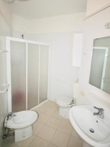 リニャーノ・サッビアドーロにあるBA- LA TORRE - Sea View -の白いバスルーム(トイレ、シンク付)