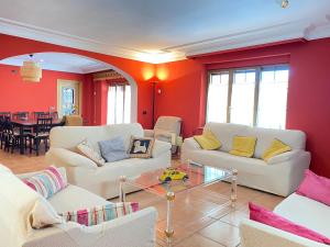 un soggiorno con pareti rosse e divani bianchi di Casa Pedraza CON PISCINA PRIVADA a Machacón