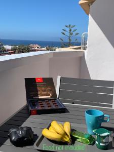 a box of food not included on a table with bananas at Superb seaview apartment in Playa de Las Americas in Playa de las Americas