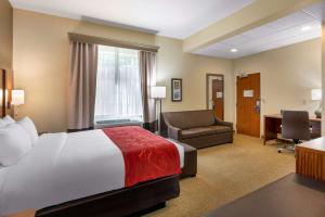 Habitación de hotel con cama, silla y escritorio. en Comfort Suites Eugene, en Eugene