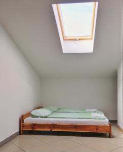 a bed in a white room with a window at Apartamenty w Młynie in Gostynin