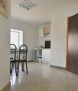 a kitchen and dining room with a table and chairs at Apartamenty w Młynie in Gostynin