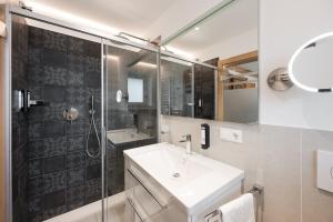 a bathroom with a sink and a shower at Hotel Alpenhof in Tirolo