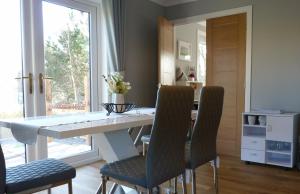 una sala da pranzo con tavolo e sedie bianchi di Tanleys B&B a Grantown on Spey