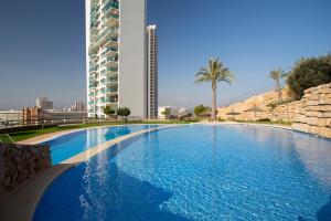 une grande piscine en face d'un grand bâtiment dans l'établissement Sunny balcony with stunning sea views, à Benidorm