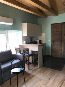 ein Wohnzimmer mit einem Sofa und einem Tisch sowie eine Küche in der Unterkunft Daukanto apartamentai in Anykščiai