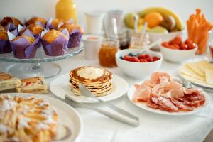 a table topped with plates of breakfast foods and fruit at Agriturismo Casa di Campagna in Riva del Garda